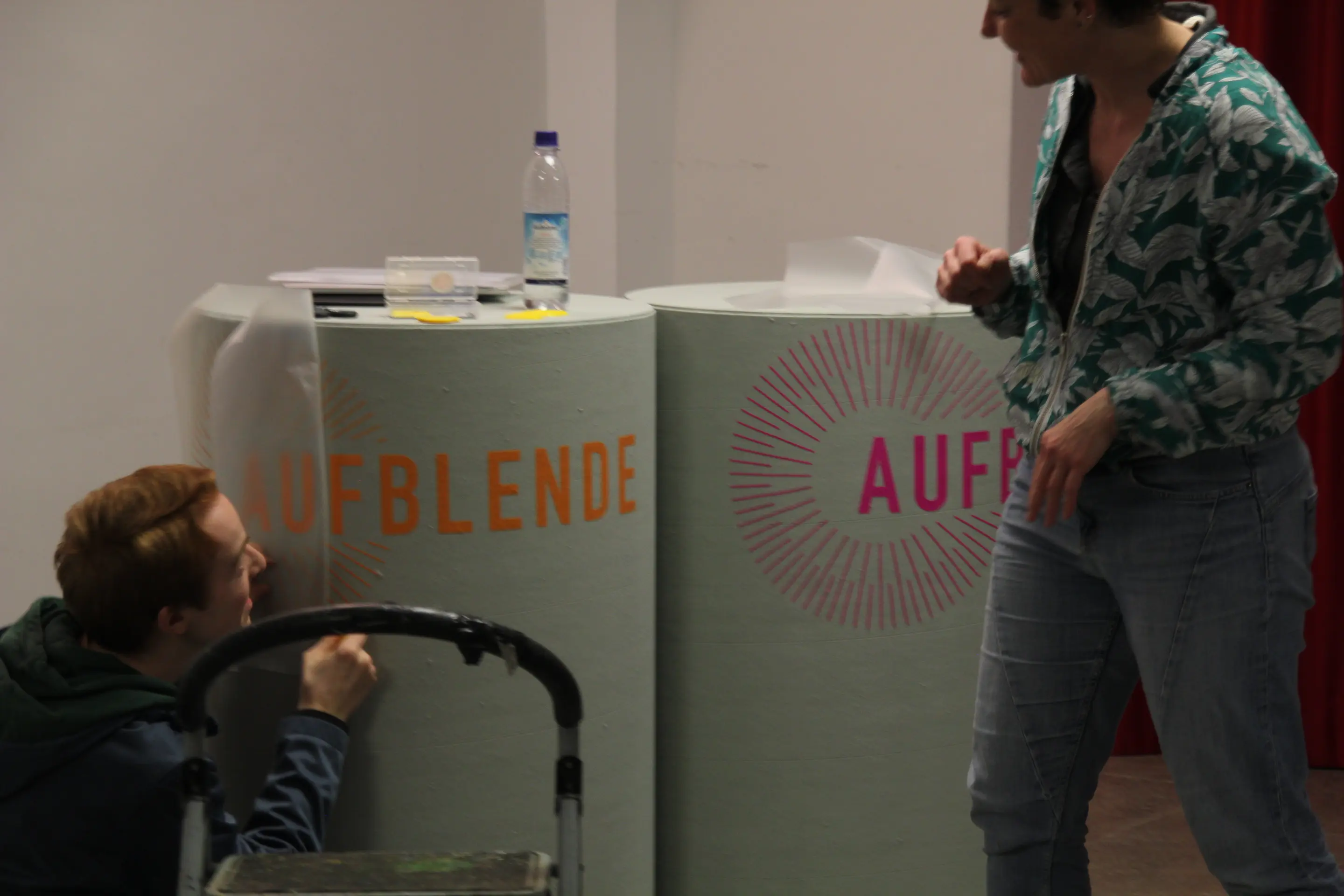 Die AUFBLENDE2024-Tonnen für die Moderation werden mit einer Beschriftung versehen.