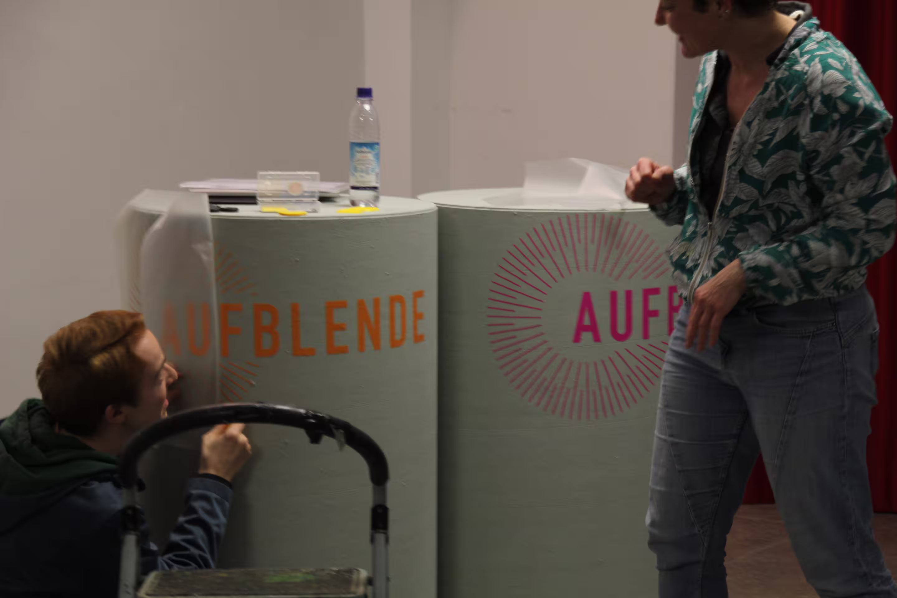 Die AUFBLENDE2024-Tonnen für die Moderation werden mit einer Beschriftung versehen.